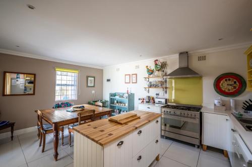 a kitchen with a wooden table and a kitchen with a dining room at The Lookout Guest House in Port Alfred