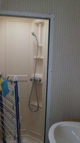 a shower in a bathroom next to a sink at Mobilhome 2 calme et tranquilité in Vendays-Montalivet