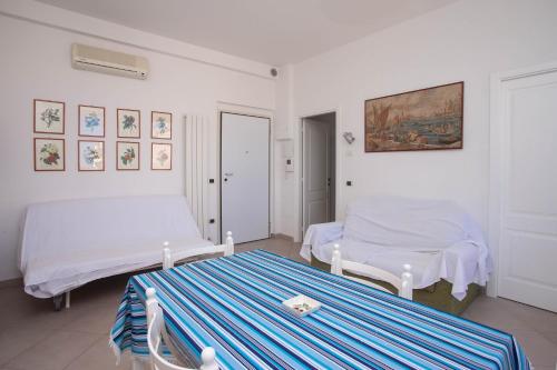 a white room with two beds and a table at N236 - Numana, bilocale vista mare nel cuore del paese in Numana