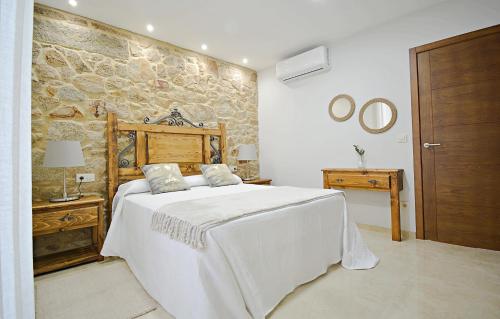 a bedroom with a bed and a stone wall at GALIHOST - Preciosa casa marinera en Carril in Vilagarcia de Arousa