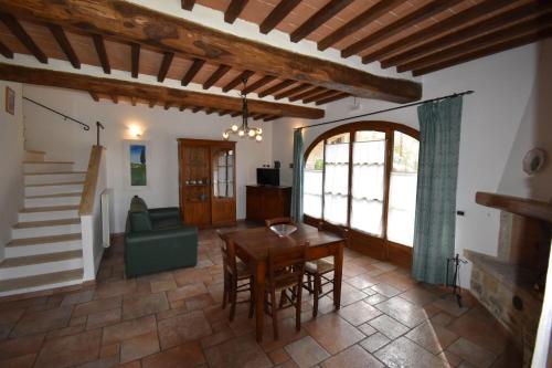 a living room with a wooden table and a chair at Falesta in Casole dʼElsa