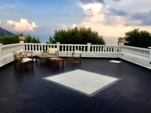 a patio with tables and chairs on a balcony at Capovaticano - Unique SEA VIEW - Villa Renaissance in Santa Maria