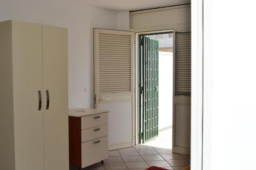 een keuken met witte kasten en een deur die naar een deuropening leidt bij Quadrilocale con vista mare Pt51 in Torre dell'Orso