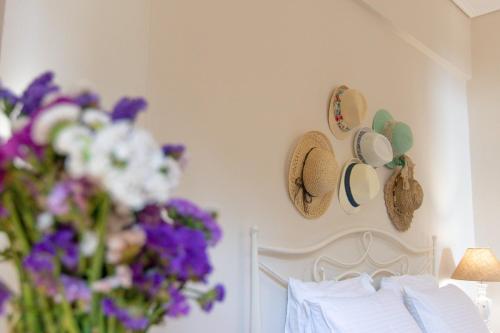 a bedroom with a bed with flowers and hats on the wall at Pelagia Apartments in Koroni