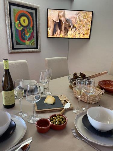 a table with a bottle of wine and wine glasses at Lovely 2 bedroom with a pool in front of the beach in Sesimbra
