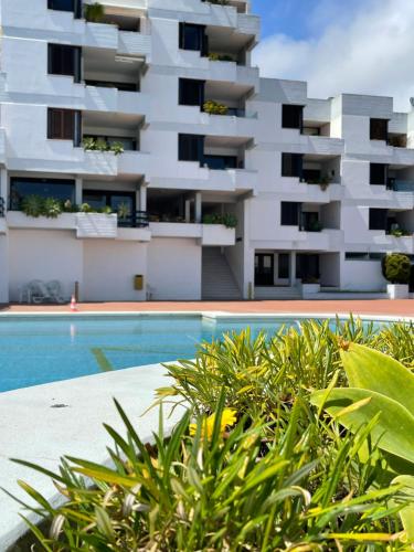 a building with a swimming pool in front of a building at Lovely 2 bedroom with a pool in front of the beach in Sesimbra