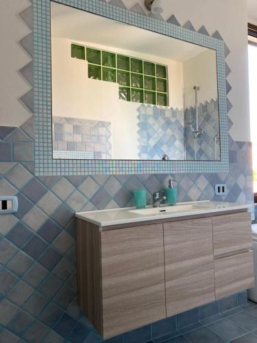 La salle de bains est pourvue d'un lavabo et d'un miroir. dans l'établissement Casa Balilla, à La Maddalena