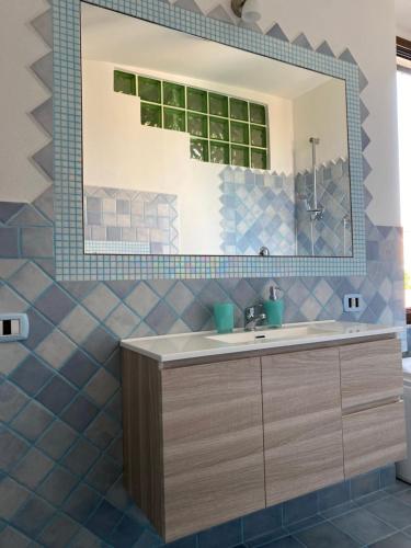 a bathroom with a sink and a mirror at Casa Balilla in La Maddalena