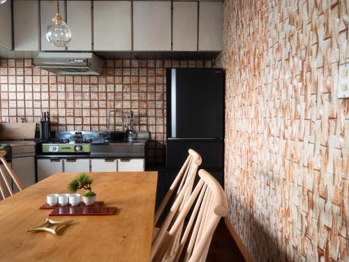 a kitchen with a wooden table and a refrigerator at SUKIYA-zukuri Suehiro in Hida