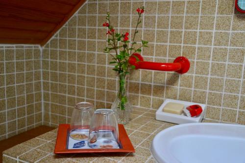 - un comptoir de salle de bains avec un plateau de nourriture et un vase avec des fleurs dans l'établissement Isis et Horus ressourcement, à Scaër