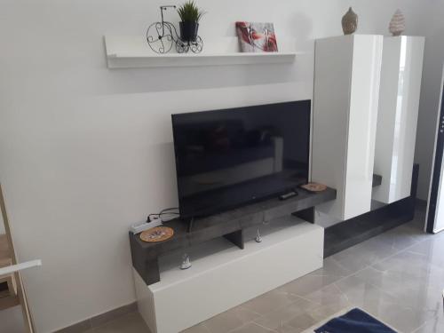 a flat screen tv on a white wall at Casa Ciuzza in Siracusa