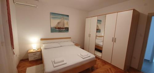 a small bedroom with a bed and a white cabinet at Villa Anja Lux, Split in Split