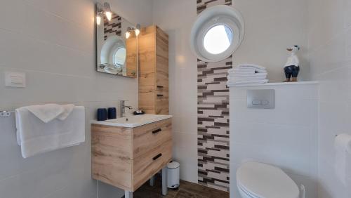 ein Badezimmer mit einem Waschbecken, einem WC und einem Spiegel in der Unterkunft L'Escale Evel Er Gêr in Locquirec