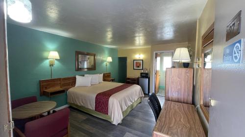 a hotel room with a bed and a table at American inn in Elko