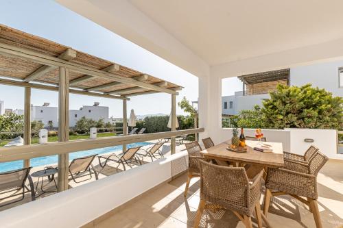 a patio with a table and chairs on a balcony at Sea & Olives Suites Hotel and Villas in Plaka