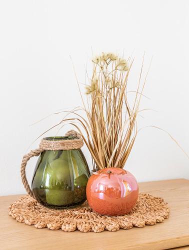 a table with a vase and a pumpkin and flowers at Ferienhaus Schlagerbauer Biohof in Salzburg