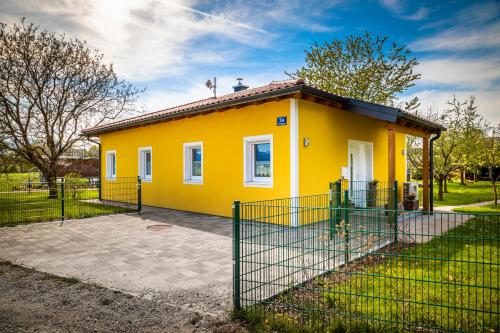 a yellow house with a fence in front of it at Ferienhaus Schlagerbauer Biohof in Salzburg