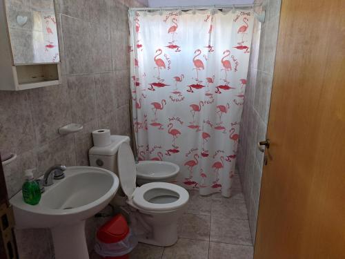 baño con aseo y cortina de ducha con flamencos en Departamento Los Sauces en San Rafael