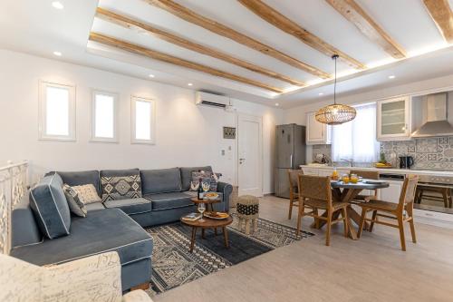 a living room with a blue couch and a table at Sea & Olives Suites Hotel and Villas in Plaka