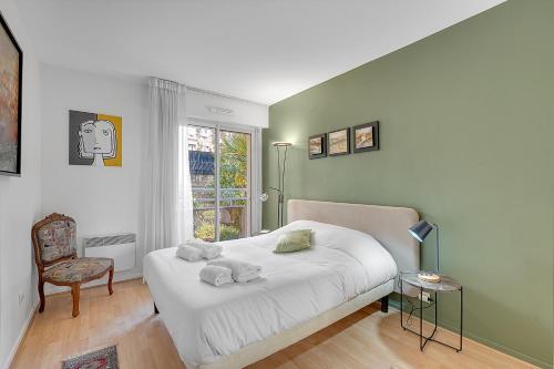 a bedroom with a white bed and a window at LES JARDINS DE L'OLYMPE - Appartement lumineux de 137m2 in Toulouse