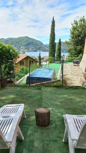 un cortile con due panche bianche e un tronco d'albero di Villa Bertacchi - inside and out Como a Como