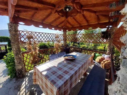 a table and chairs under an umbrella on a patio at Prespa`s Balcony Guesthouse in Gorica e Vogël