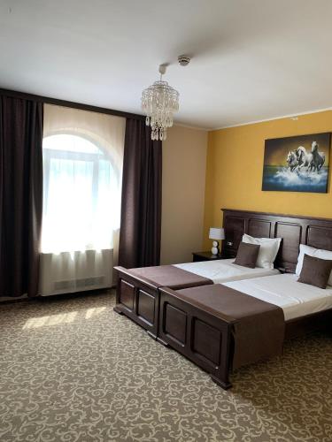 a large bedroom with two beds and a chandelier at Laura Holiday in Brăila