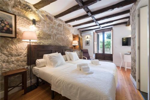 a bedroom with a large bed with two towels on it at Casa da Muralha in Porto