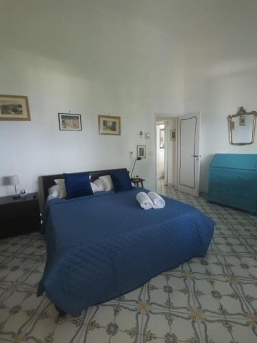 a bedroom with a large blue bed with blue sheets at TERRAZZA Marina Piccola in Capri