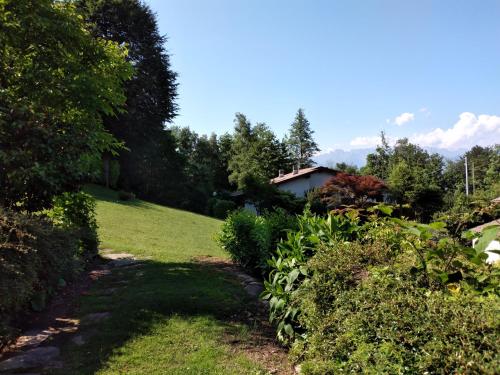 un sentiero attraverso un giardino con una casa sullo sfondo di Maison Al Nocino a Stresa