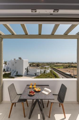 a table and chairs on a balcony with a view at Sea & Olives Suites Hotel and Villas in Plaka