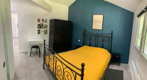 een slaapkamer met een bed met een gele deken bij Maison indépendante 42m2. Calme et verdure :) in Landorthe