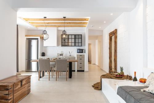 a kitchen and living room with a table and chairs at Sea & Olives Suites Hotel and Villas in Plaka