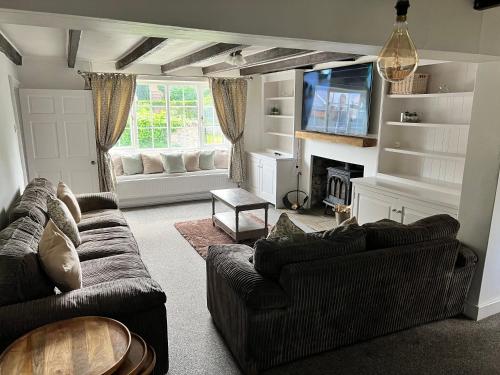a living room with two couches and a tv at Southview in Ganton
