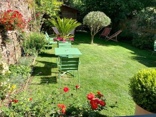 a garden with chairs and flowers in the grass at Hôtel Coeur De Loire in Nantes