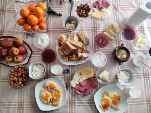 a table topped with plates of food and fruit at Mountain Horse Trekking Guesthouse in Karakol