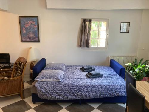 a bedroom with a blue bed and a window at Calme et spacieux près du Loing et du centre in Moret-sur-Loing