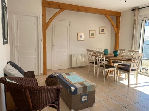 un salon avec une table et des chaises dans l'établissement Maison Vendéenne à 10 min de la mer, à Avrillé