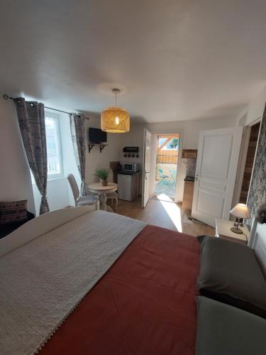 a bedroom with a large bed and a kitchen at Les Petits Jardins de Cissé Chambre de Charme in Cissé