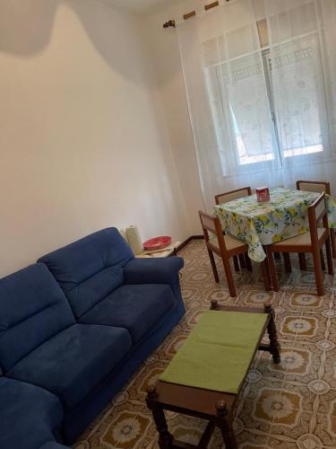 a living room with a blue couch and a table at da Lilia in Salute&Bellezza in Monfalcone