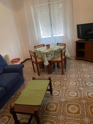a living room with a table and a blue couch at da Lilia in Salute&Bellezza in Monfalcone