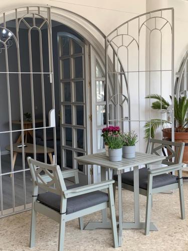une table, deux chaises et une table avec des fleurs dans l'établissement Kentia Rooms Torremolinos, à Torremolinos