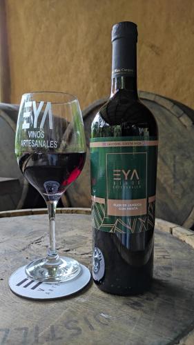 a bottle of wine next to a glass of red wine at EYA Ecolodge in San Isidro
