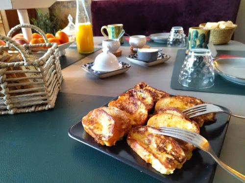 a plate of food with chicken and a fork on a table at chambres d'hôtes Le Carillon in Bergues