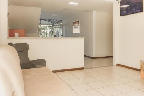 une salle d'attente avec des chaises et un comptoir blanc dans l'établissement Hotel Girafa, à Itatiaia