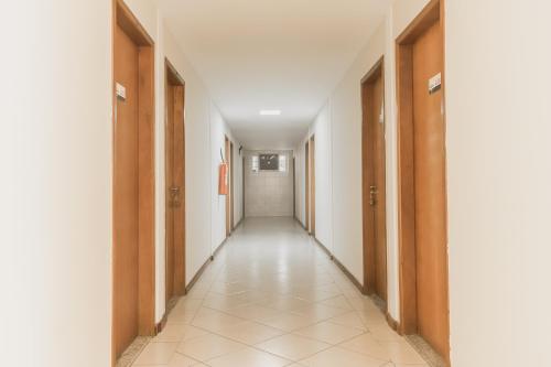a corridor of an empty hallway with wooden doors at Hotel Girafa in Itatiaia