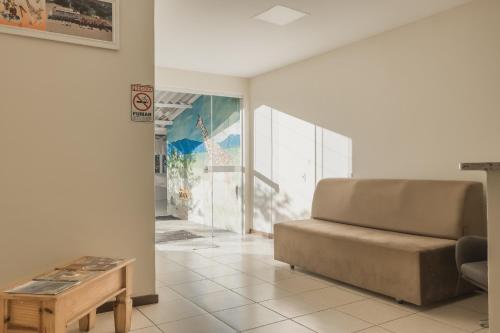 ein Wohnzimmer mit einem Sofa und einem Tisch in der Unterkunft Hotel Girafa in Itatiaia