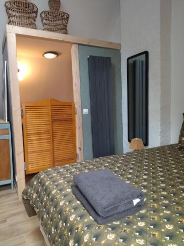 a bedroom with a bed with a blue towel on it at chambres d'hôtes Le Carillon in Bergues