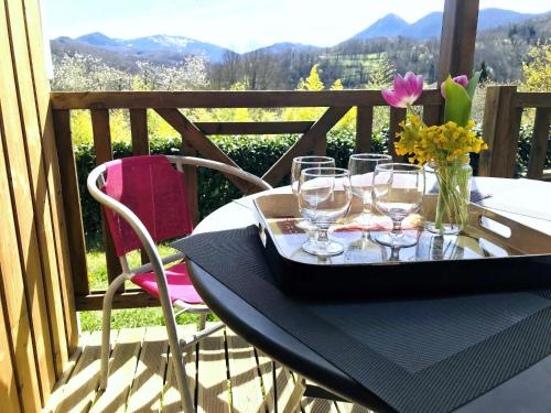 een tafel met wijnglazen en een vaas met bloemen bij Camping-Gites Au songe du Valier in Seix