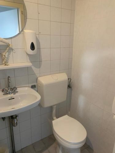 a white bathroom with a toilet and a sink at CoronaZeist-Utrecht NL in Zeist